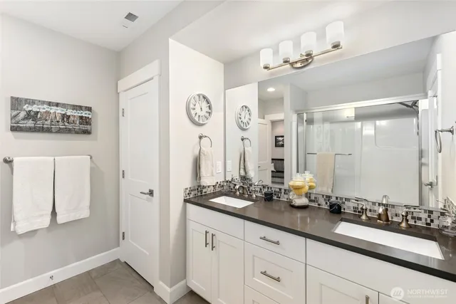 a bathroom with a double vanity sink and a mirror