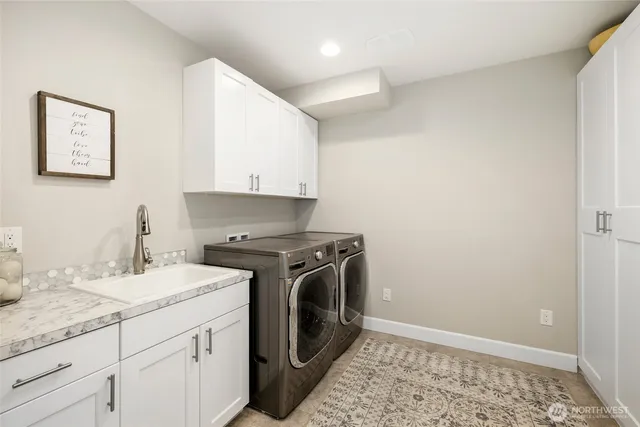 a utility room with sink dryer and washer