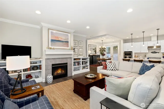 a living room with furniture fireplace and kitchen view