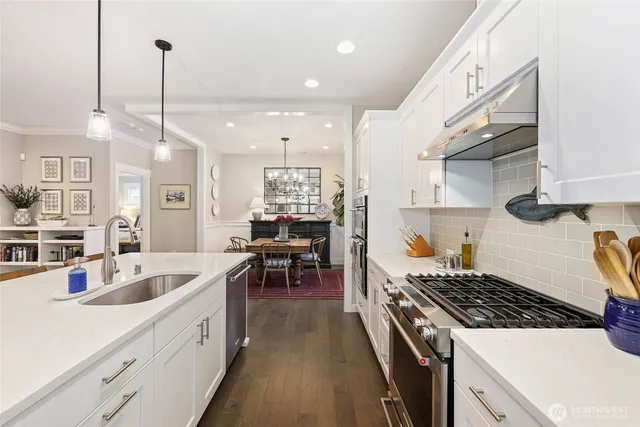 a kitchen with stove a sink and chairs