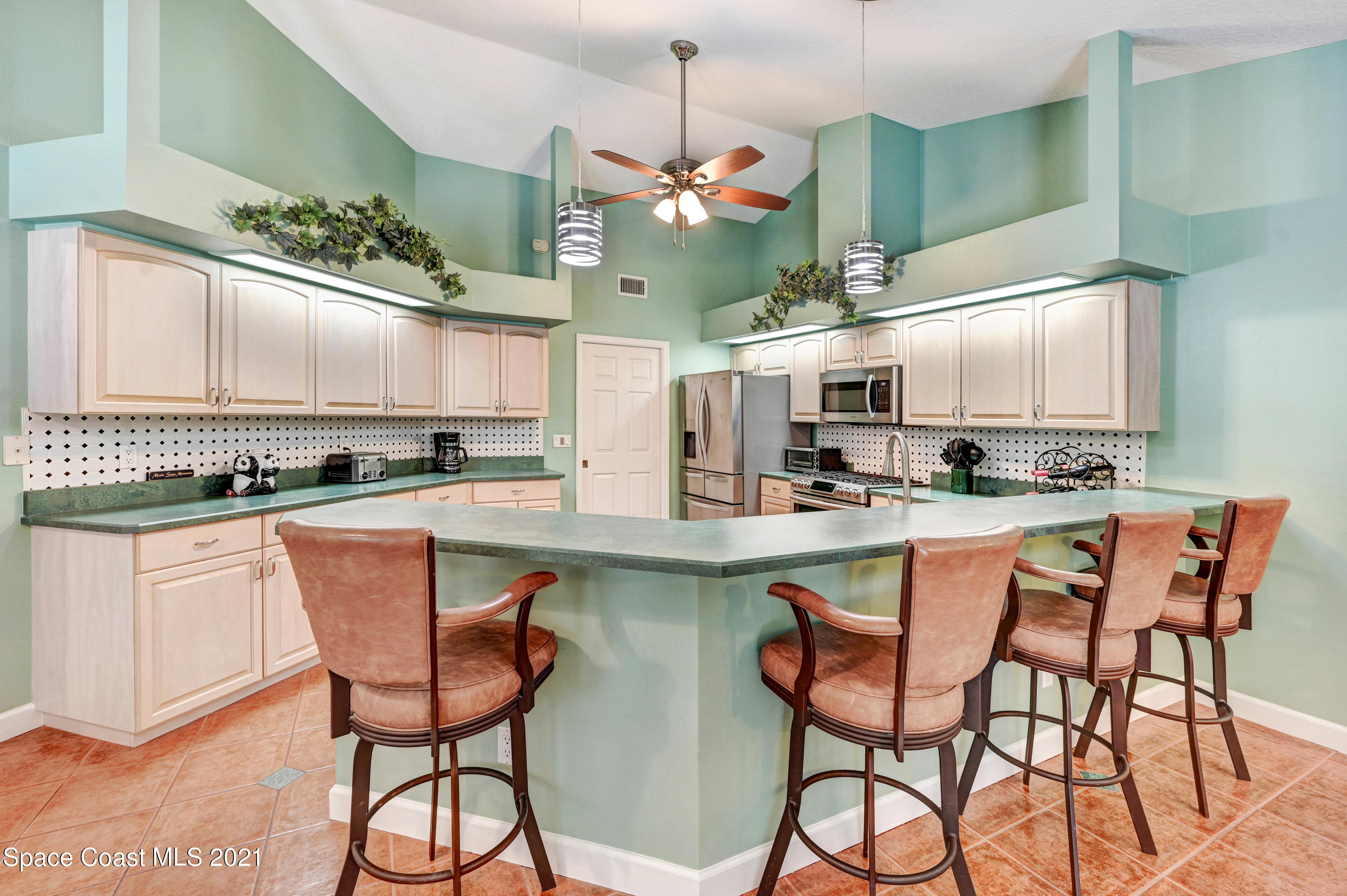 4689 Canard Road Melbourne, FL 32934 - Photo 18 of 49 a kitchen with stainless steel appliances granite countertop a stove a sink refrigerator and cabinets