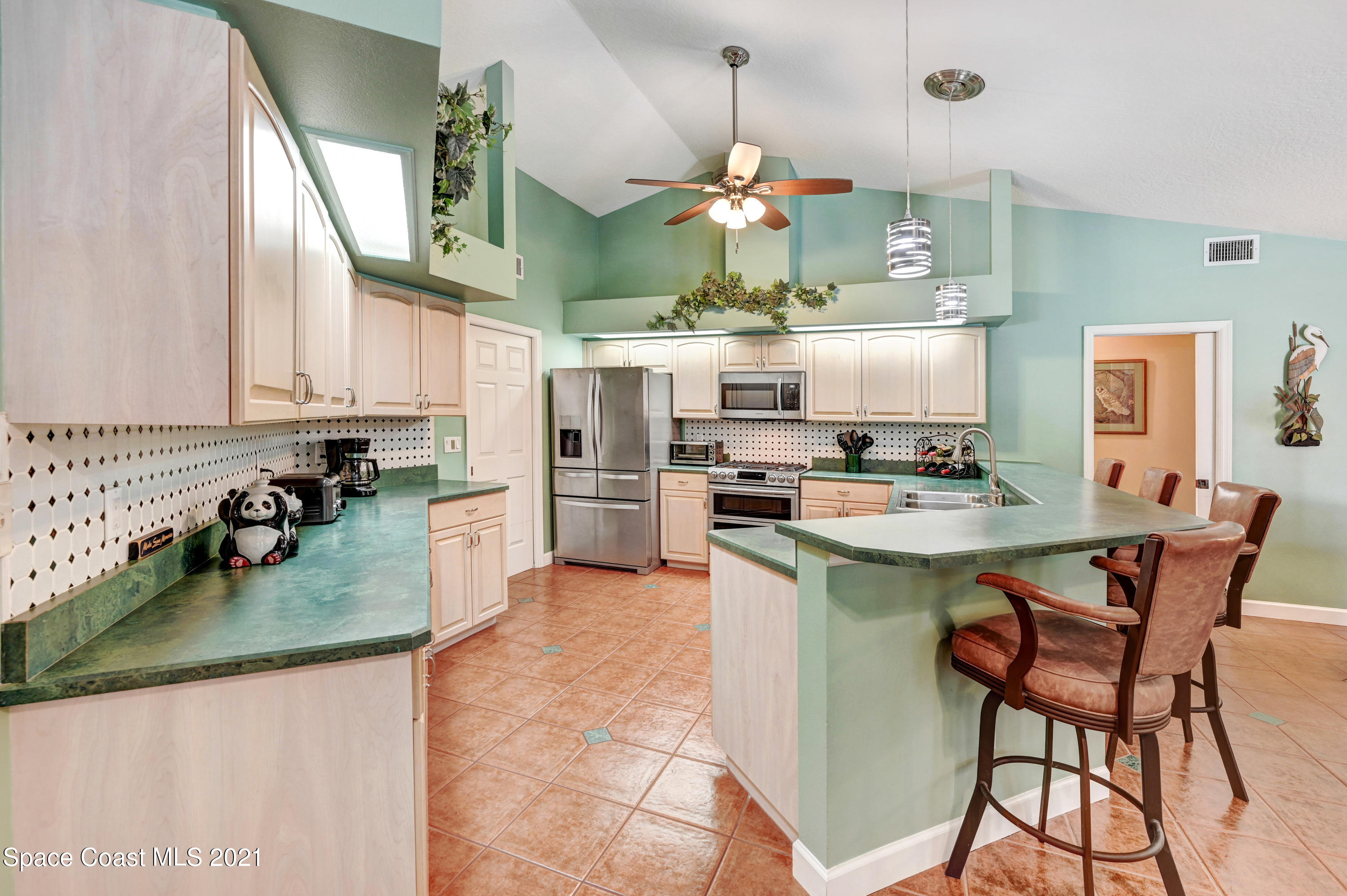 4689 Canard Road Melbourne, FL 32934 - Photo 20 of 49 a kitchen with stainless steel appliances granite countertop a sink a stove and a wooden floors
