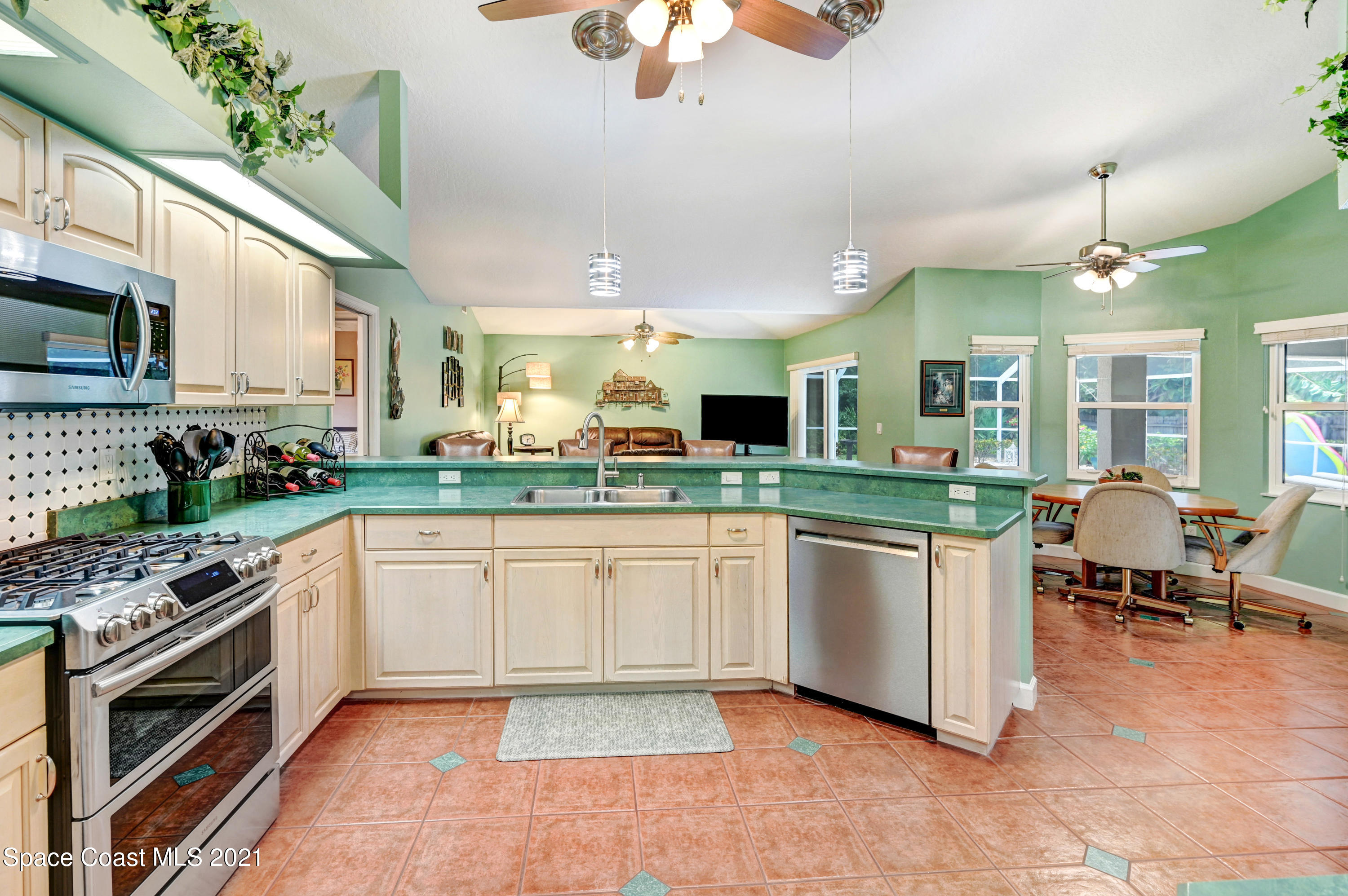 4689 Canard Road Melbourne, FL 32934 - Photo 21 of 49 a kitchen with stainless steel appliances granite countertop a stove and a sink