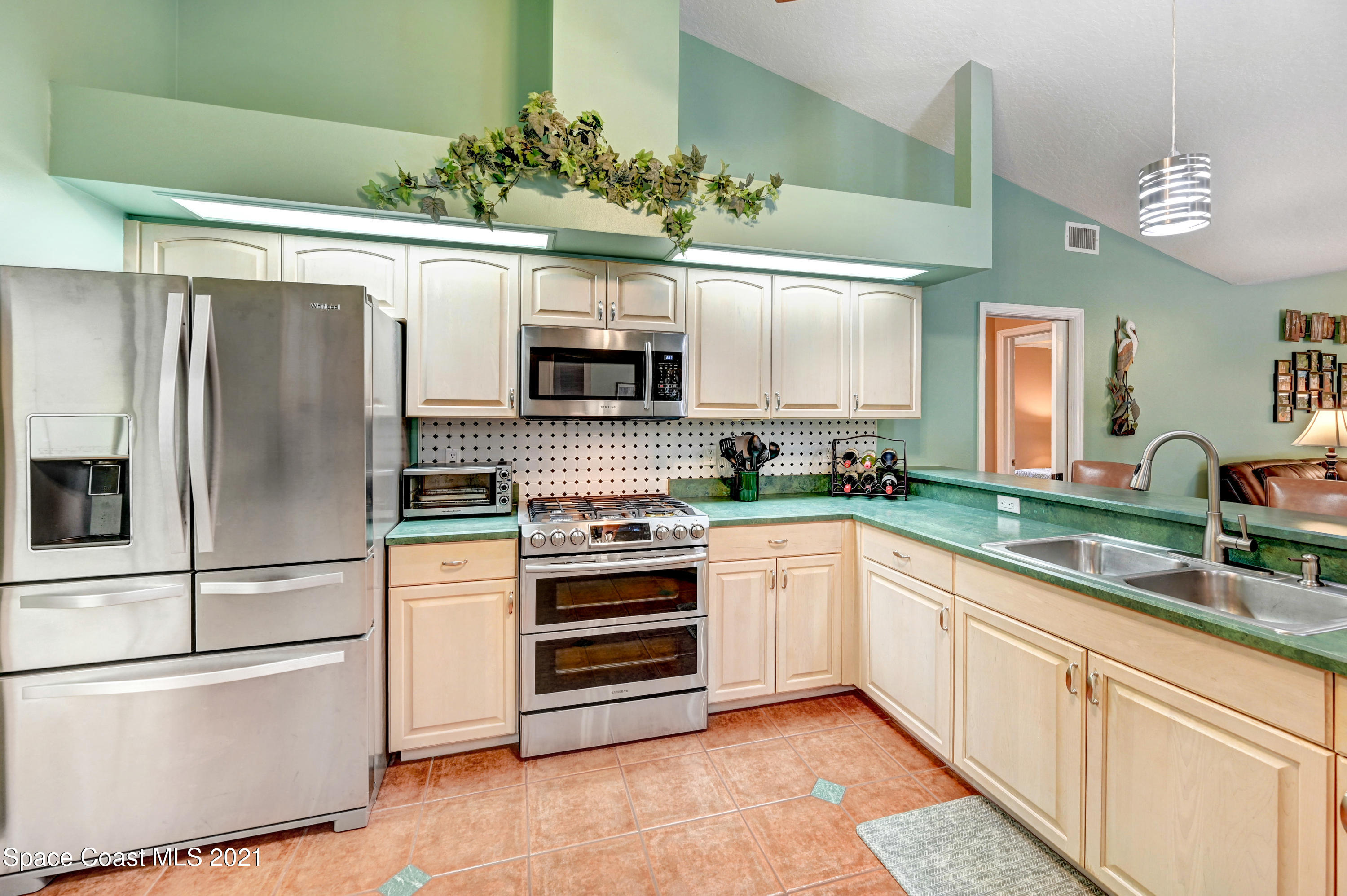 4689 Canard Road Melbourne, FL 32934 - Photo 22 of 49 a kitchen with granite countertop a refrigerator and a sink