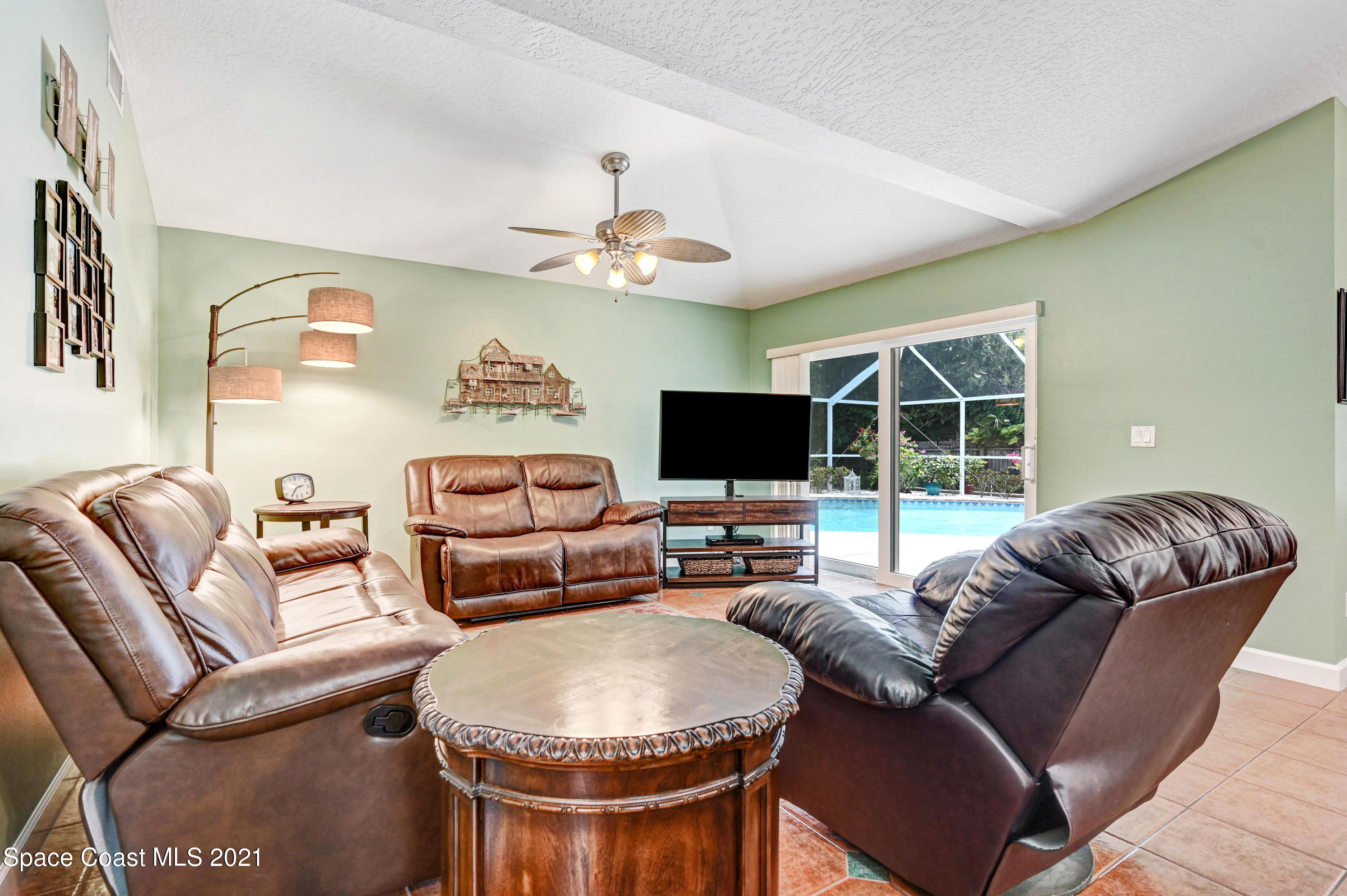 4689 Canard Road Melbourne, FL 32934 - Photo 26 of 49 a living room with furniture a flat screen tv and a large window