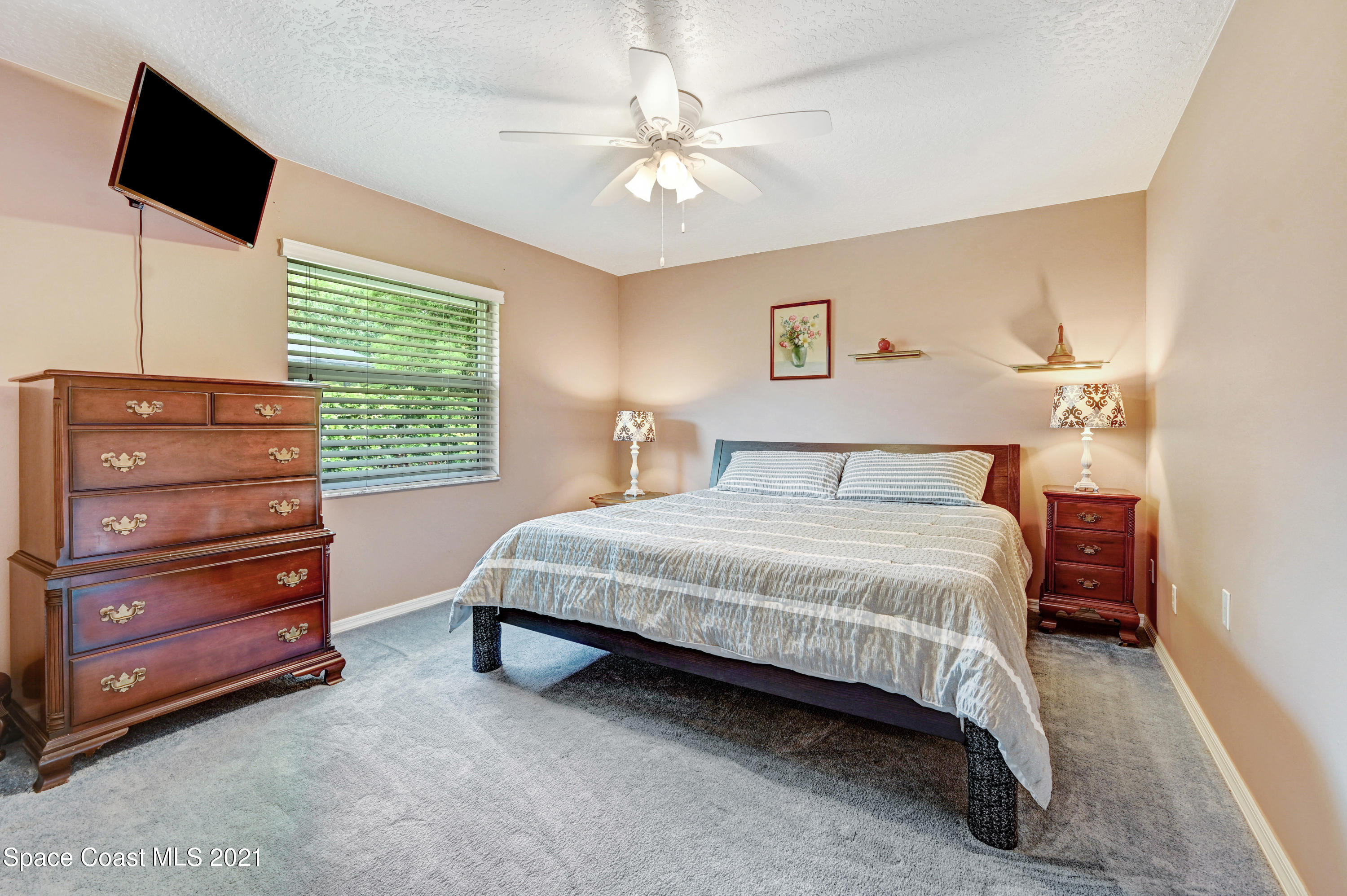 4689 Canard Road Melbourne, FL 32934 - Photo 29 of 49 a bedroom with a bed and a flat screen tv