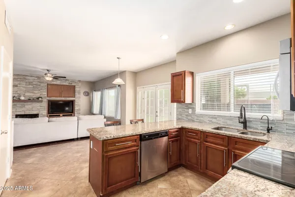a large kitchen with granite countertop a sink and a stove top oven