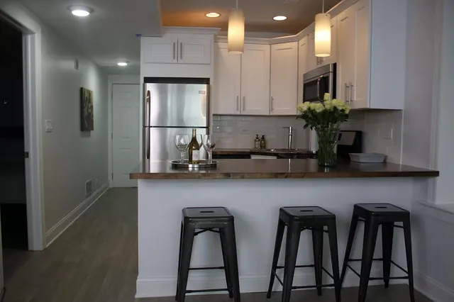 a kitchen with stainless steel appliances a sink a refrigerator a stove a microwave and cabinets