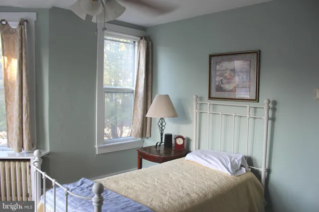 a bedroom with a bed and a lamp on dresser