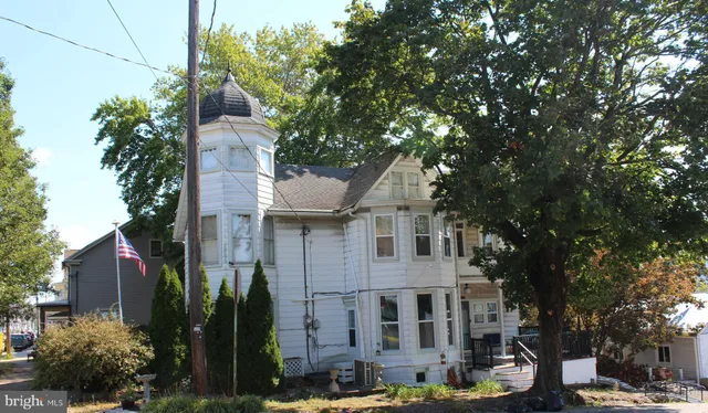 a front view of a house with a tree