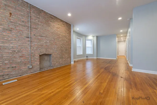 a view of empty room with wooden floor and fireplace