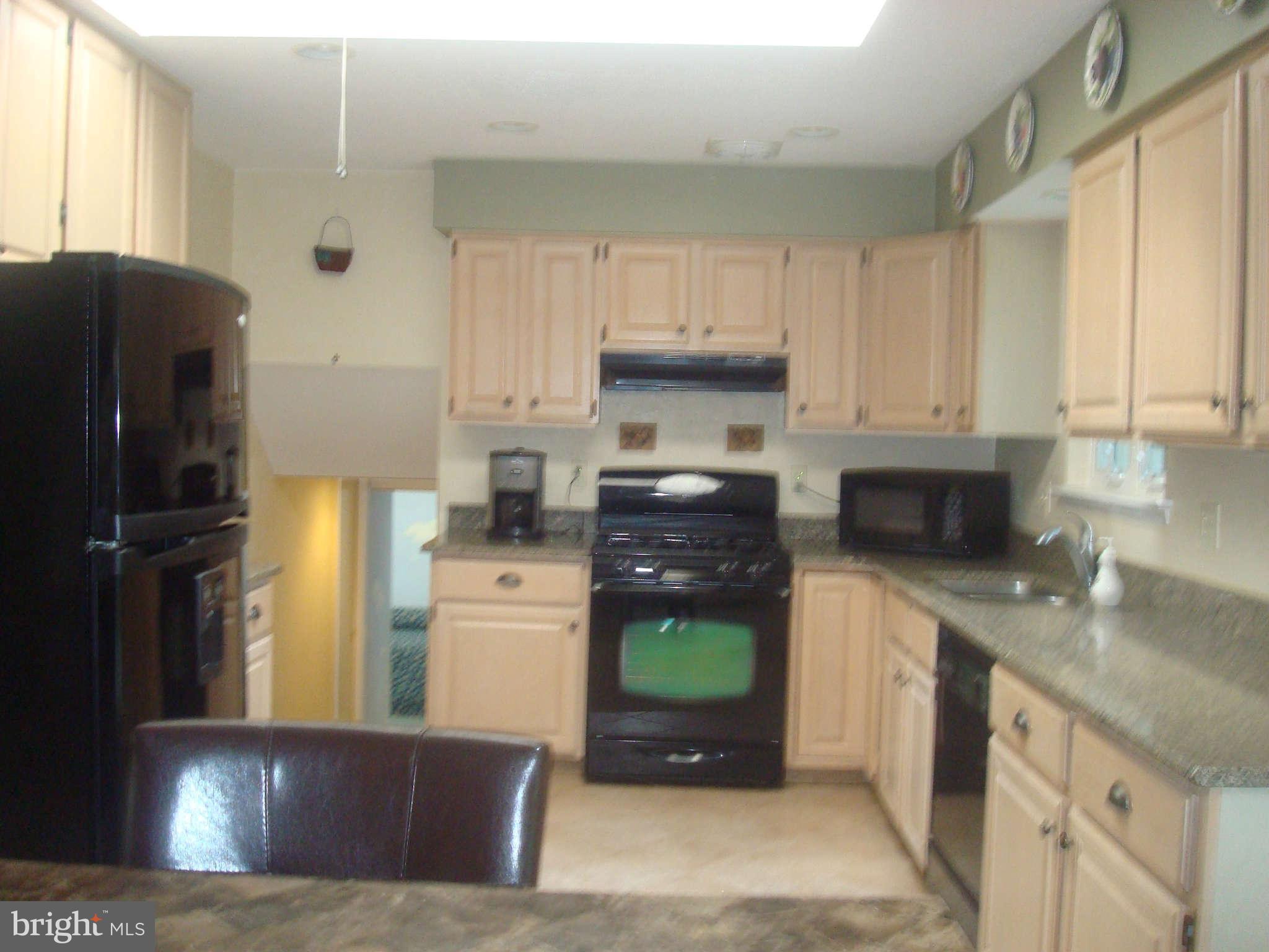 7413 Farnum Street Springfield, VA 22151 - Photo 3 of 17 a kitchen with a refrigerator and a stove top oven