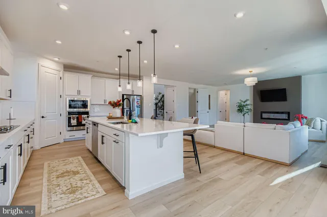 a large white kitchen with lots of counter space a sink appliances and cabinets