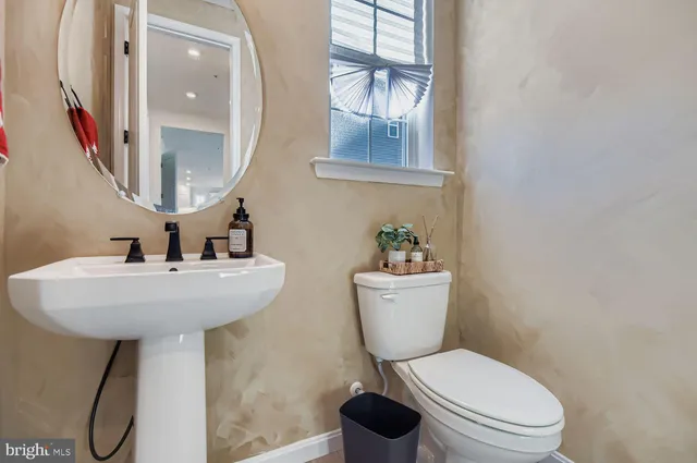 a bathroom with a toilet sink and mirror