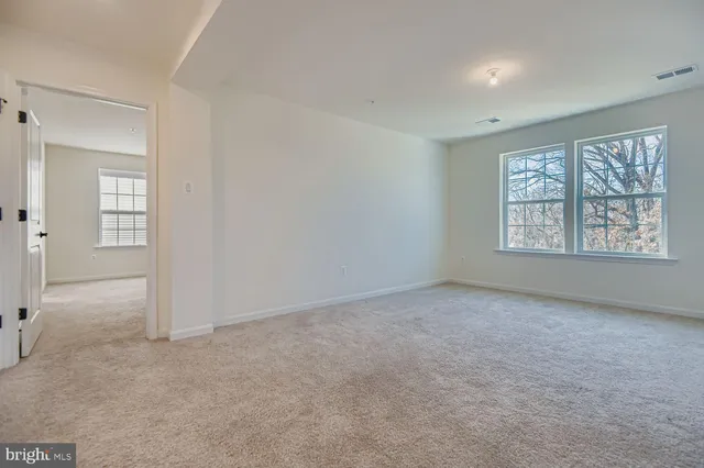 a spacious bedroom with a bed and a flat screen tv