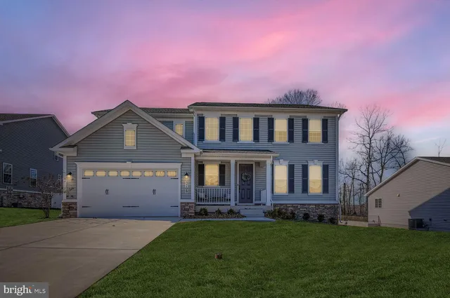 a front view of a house with a garden and yard