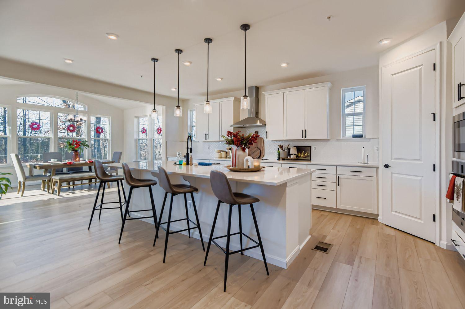 5708 Charlies Way White Marsh, MD 21162 - Photo 9 of 39 a kitchen with white cabinets sink dining table and chairs
