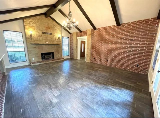 a view of empty room with wooden floor and fireplace