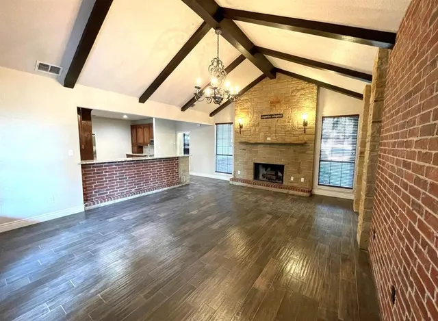 a view of empty room with fireplace and wooden floor