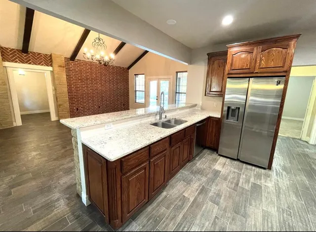 a kitchen with stainless steel appliances granite countertop a refrigerator a sink a stove and island