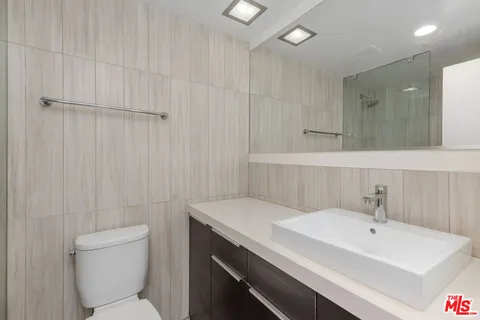 a bathroom with a sink a toilet and a mirror