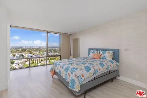 a bedroom with a bed and glass window
