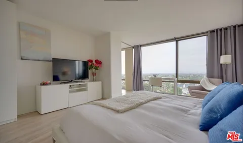 a bedroom with a large bed and a flat screen tv