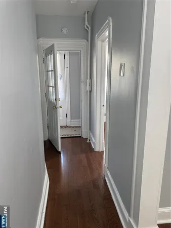 an empty room with wooden floor and mirror