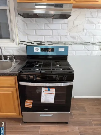 a stove top oven sitting inside of a kitchen