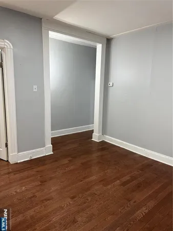 an empty room with wooden floor and closet