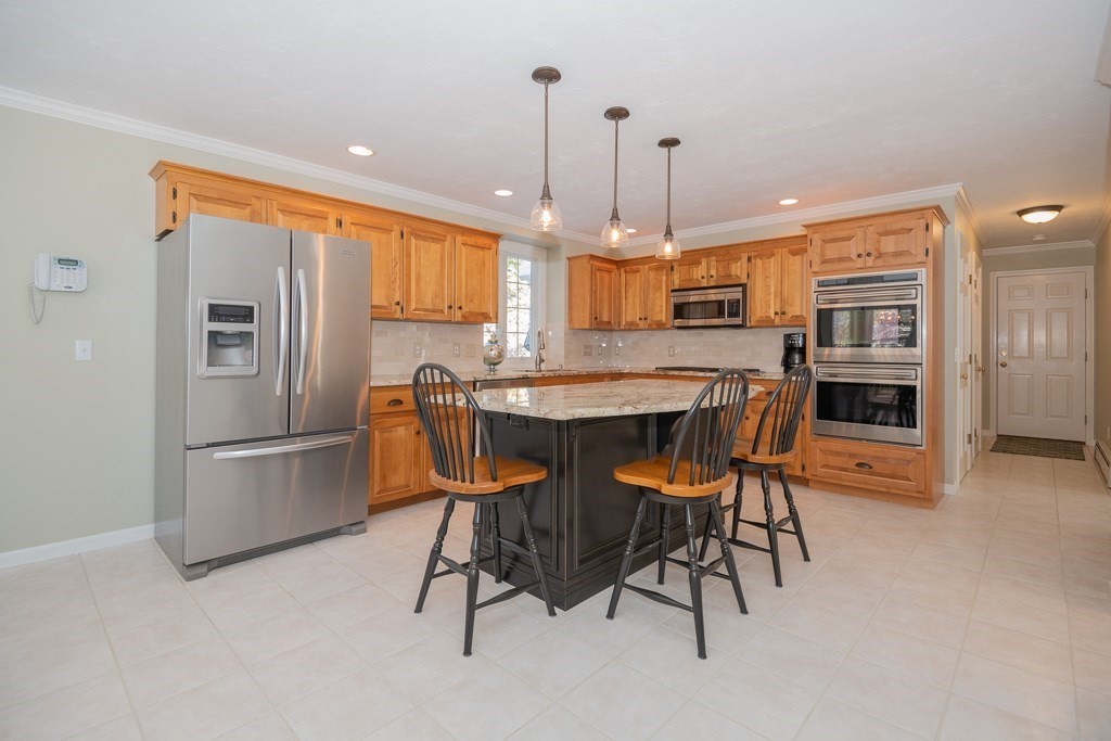 7 Round Table Road Shrewsbury, MA 01545 - Photo 3 of 39 a kitchen with stainless steel appliances kitchen island granite countertop a table chairs and a refrigerator