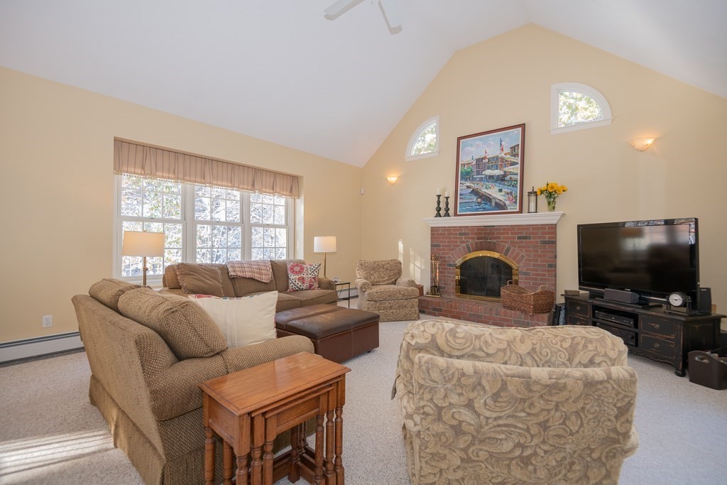 7 Round Table Road Shrewsbury, MA 01545 - Photo 9 of 39 a living room with furniture a flat screen tv and a fireplace