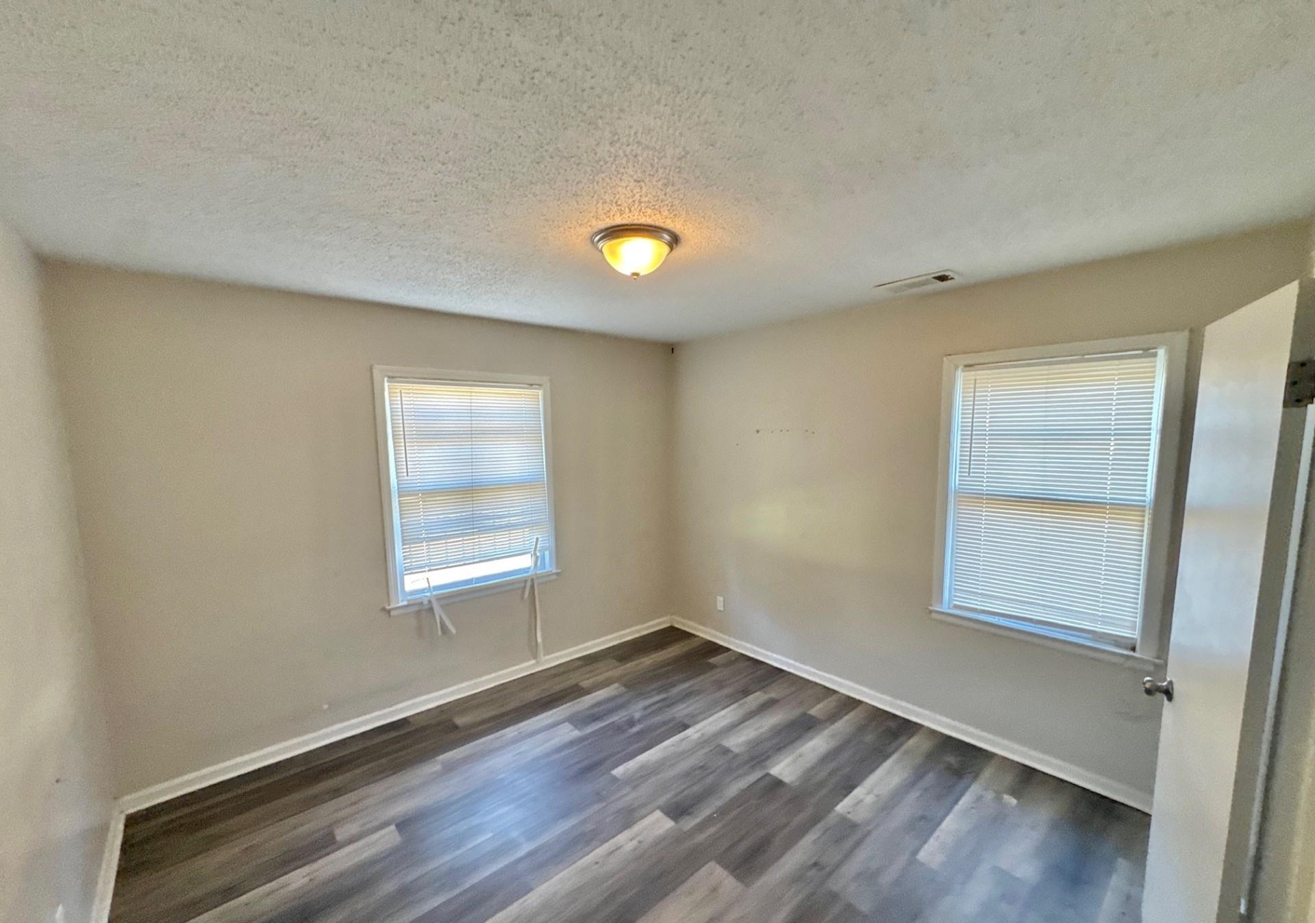 4826 Leonard Road Memphis, TN 38109 - Photo 8 of 8 Unfurnished room featuring a textured ceiling and dark wood finished floors