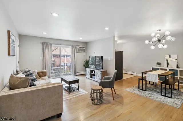 a living room with furniture a large window and dining table