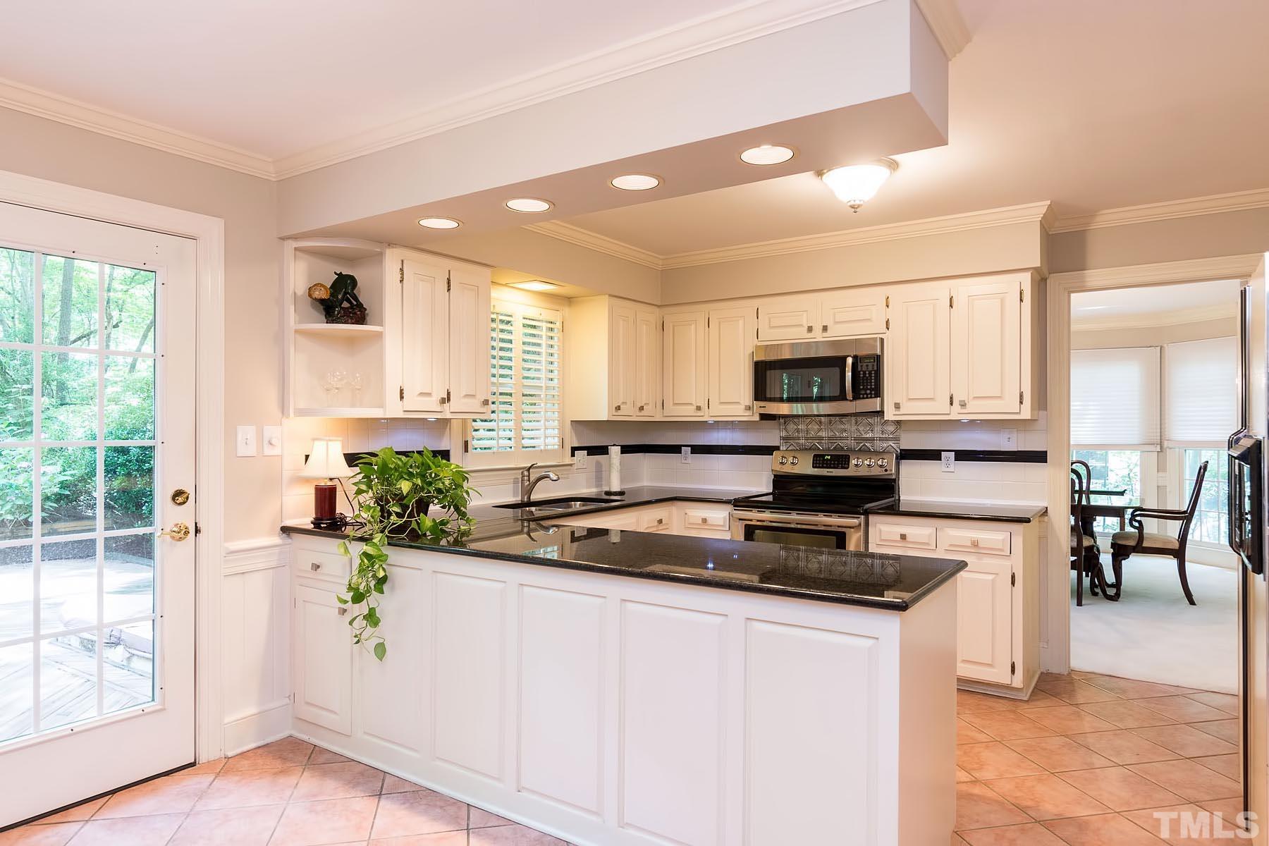 2301 Valley Forge Road Raleigh, NC 27615 - Photo 5 of 21 a kitchen with stainless steel appliances granite countertop a refrigerator a stove top oven a sink a dining table and chairs