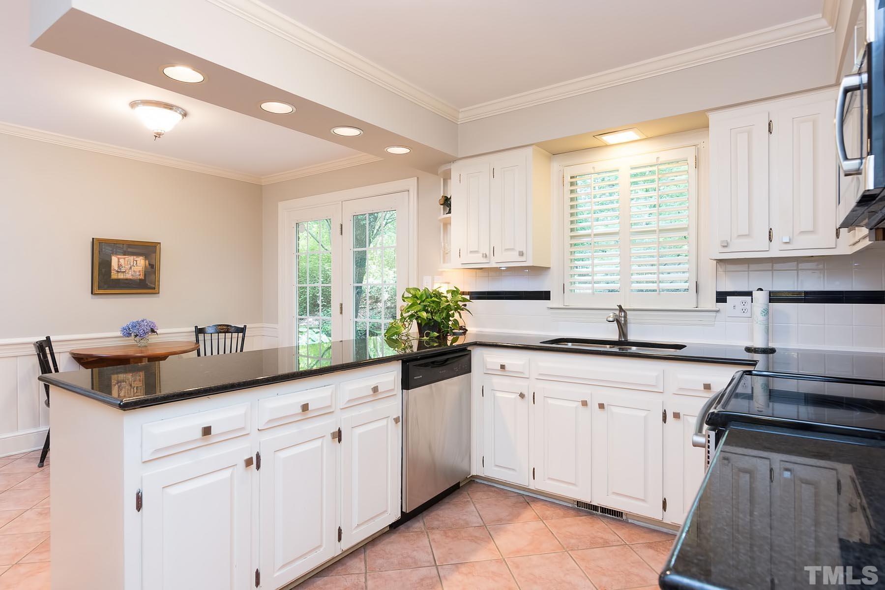 2301 Valley Forge Road Raleigh, NC 27615 - Photo 6 of 21 a kitchen with granite countertop white cabinets white appliances a sink and a window