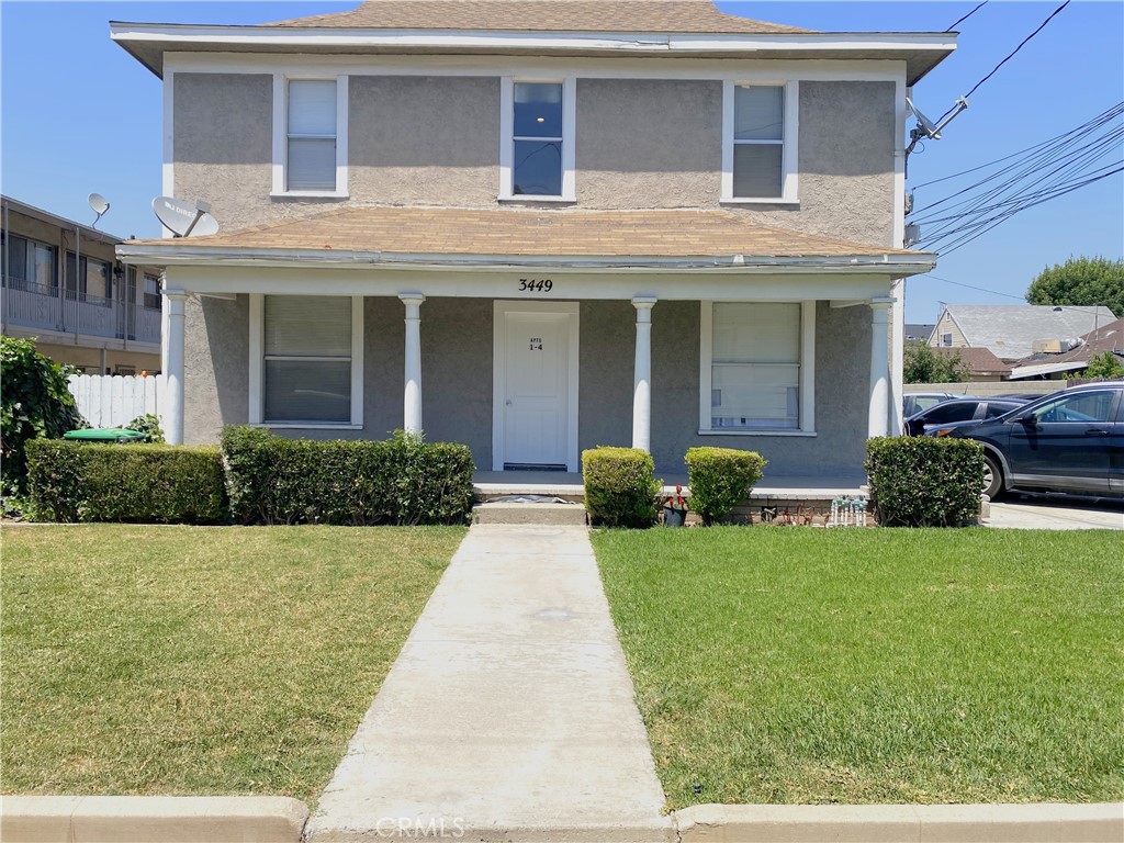 a view of a white house with a yard and potted plants