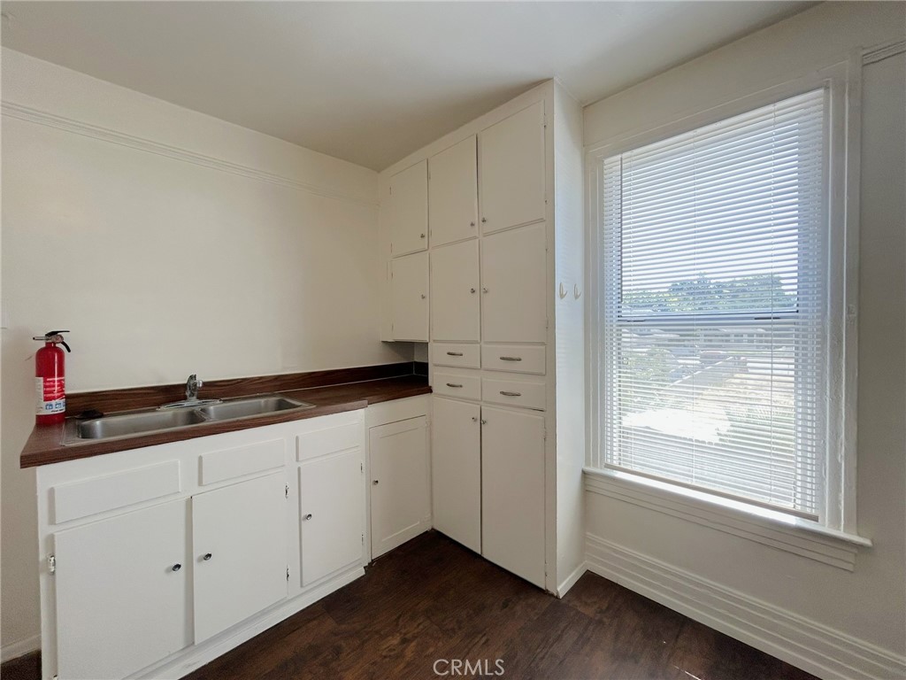 3449 4th Street, Unit 4 Riverside, CA 92501 - Photo 12 of 15 a kitchen with granite countertop white cabinets and white appliances