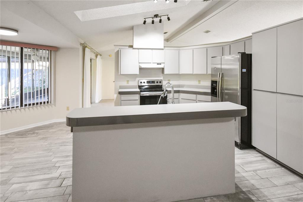 8143 Wooden Drive Spring Hill, FL 34606 - Photo 13 of 36 a kitchen with stainless steel appliances a refrigerator sink and cabinets