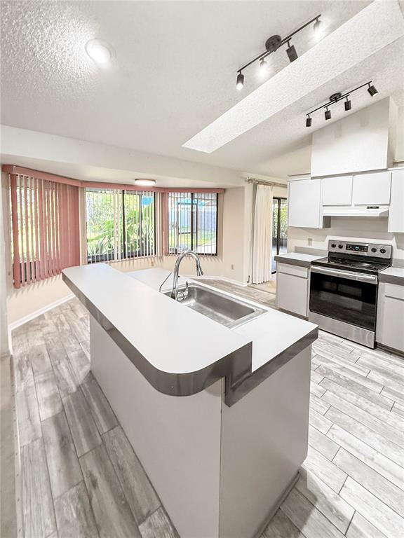 8143 Wooden Drive Spring Hill, FL 34606 - Photo 14 of 36 a kitchen with stainless steel appliances kitchen island granite countertop a sink and a stove