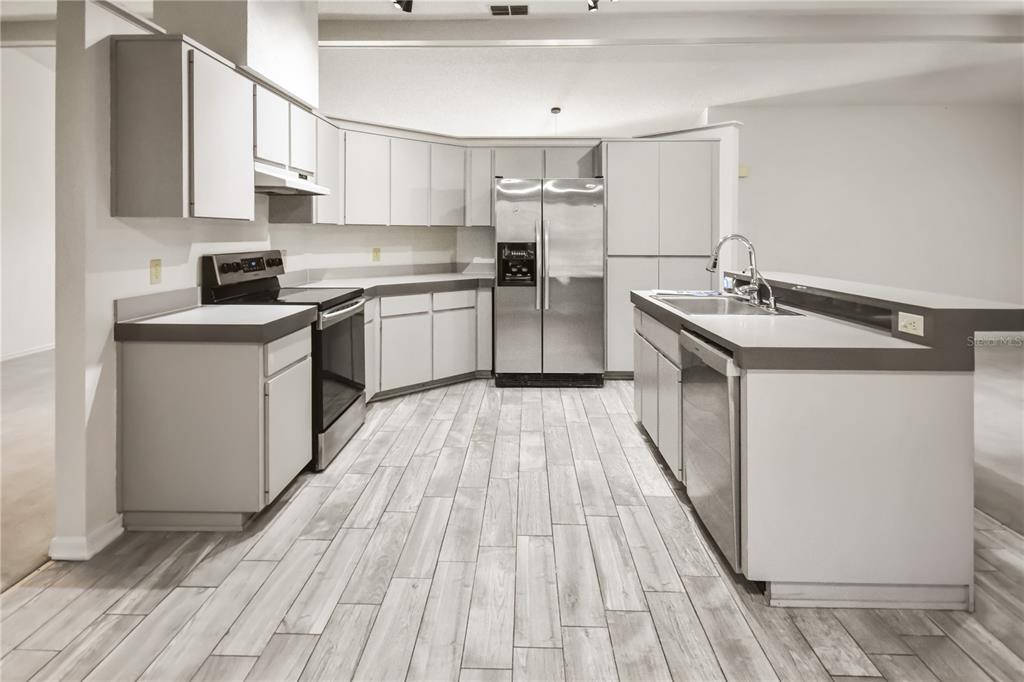 8143 Wooden Drive Spring Hill, FL 34606 - Photo 16 of 36 a kitchen with a sink stove and cabinets