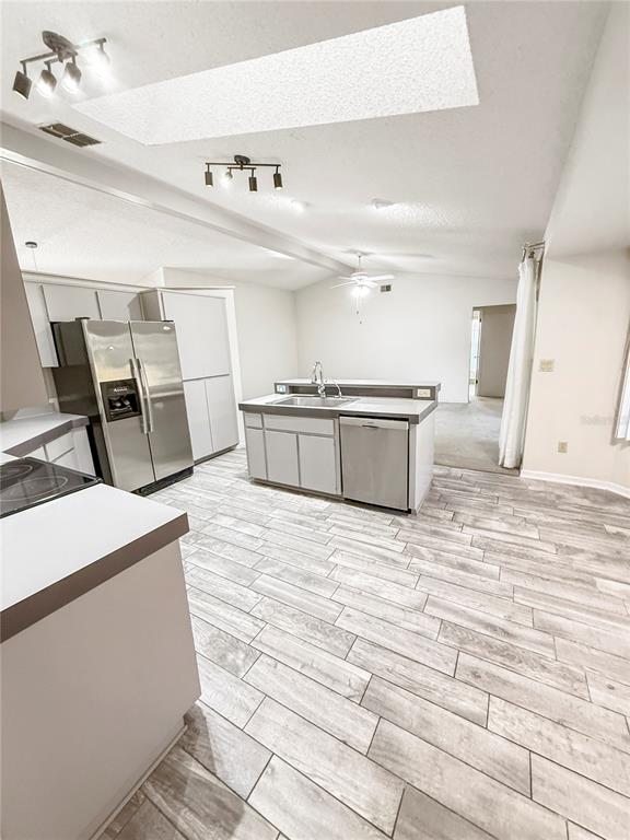 8143 Wooden Drive Spring Hill, FL 34606 - Photo 17 of 36 a large white room with kitchen island a stove a sink dishwasher and wooden cabinets