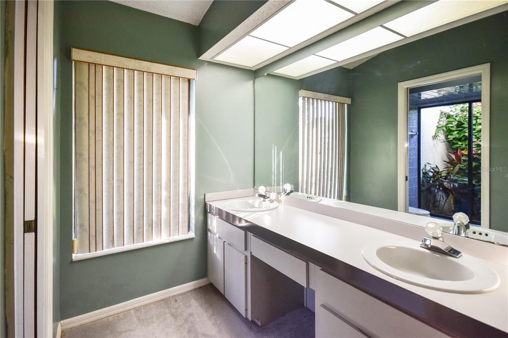 8143 Wooden Drive Spring Hill, FL 34606 - Photo 23 of 36 a bathroom with a double vanity sink and a mirror
