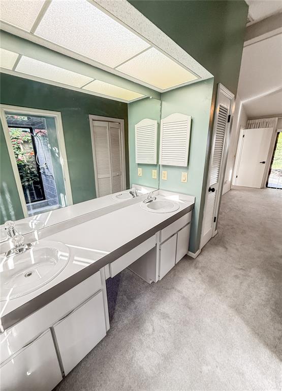 8143 Wooden Drive Spring Hill, FL 34606 - Photo 25 of 36 a spacious bathroom with a double vanity sink and mirror