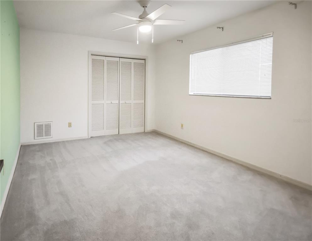 8143 Wooden Drive Spring Hill, FL 34606 - Photo 26 of 36 an empty room with a ceiling fan and windows