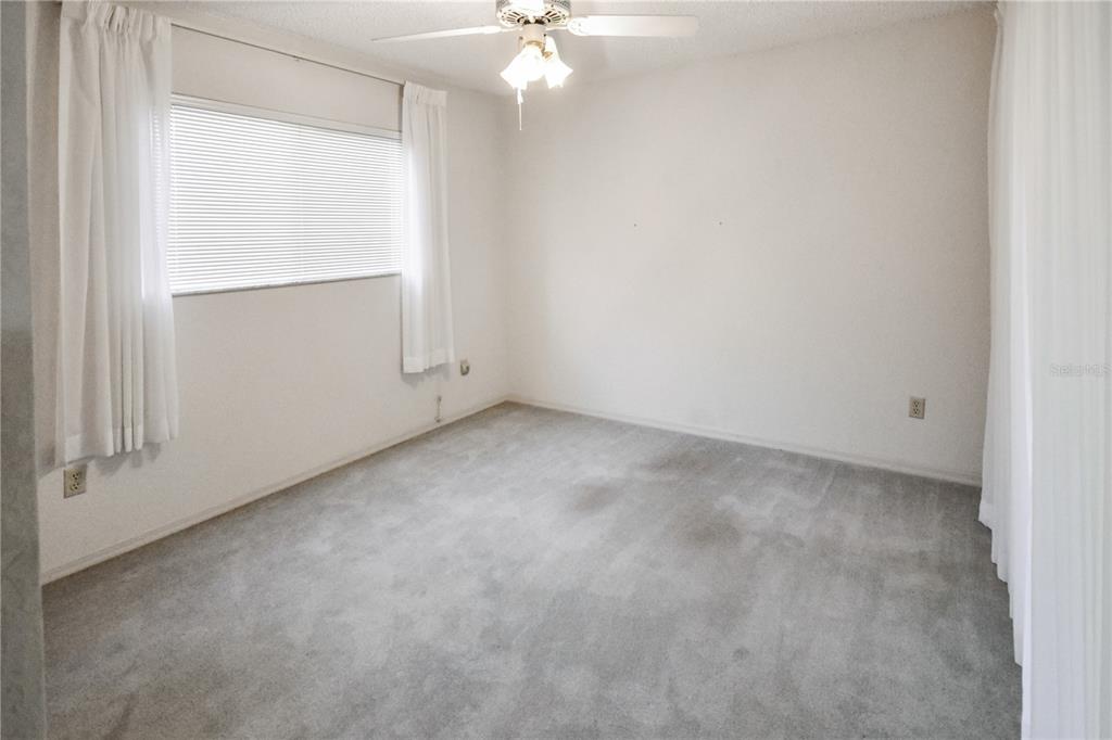 8143 Wooden Drive Spring Hill, FL 34606 - Photo 28 of 36 an empty room with a ceiling fan and a window
