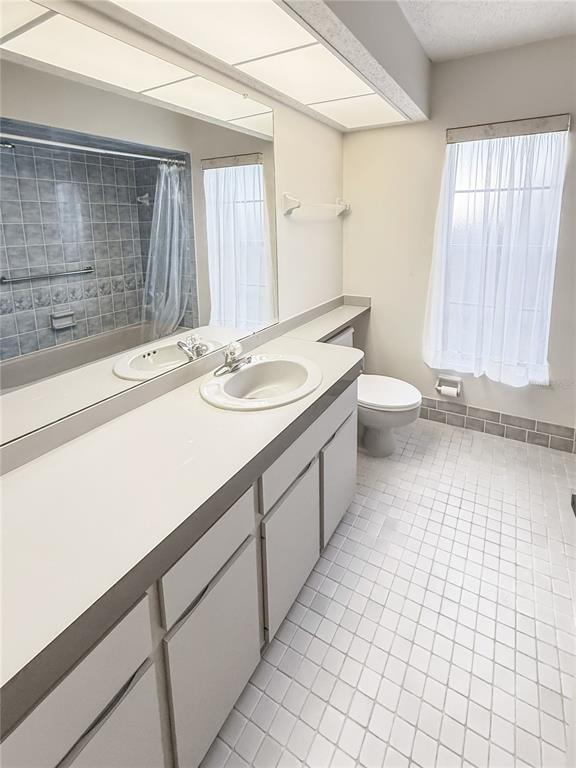 8143 Wooden Drive Spring Hill, FL 34606 - Photo 30 of 36 a bathroom with a sink a toilet and large mirror