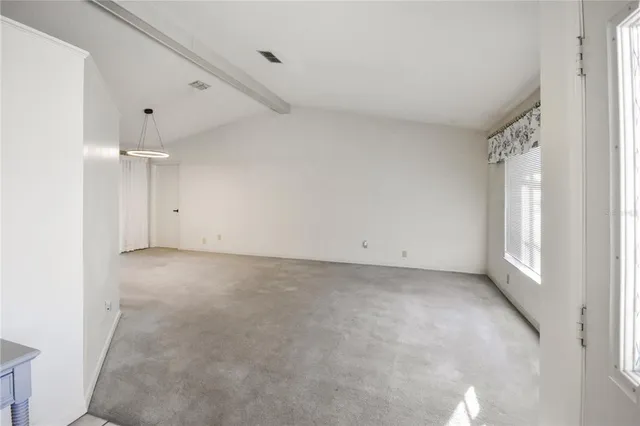 an empty room with windows and chandelier