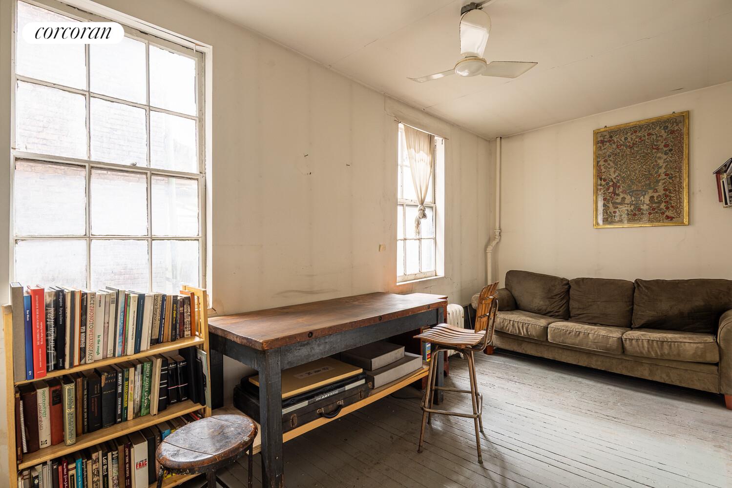 7 Bleecker Street Manhattan, NY 10012 - Photo 12 of 15 a living room with furniture a window and a book shelf