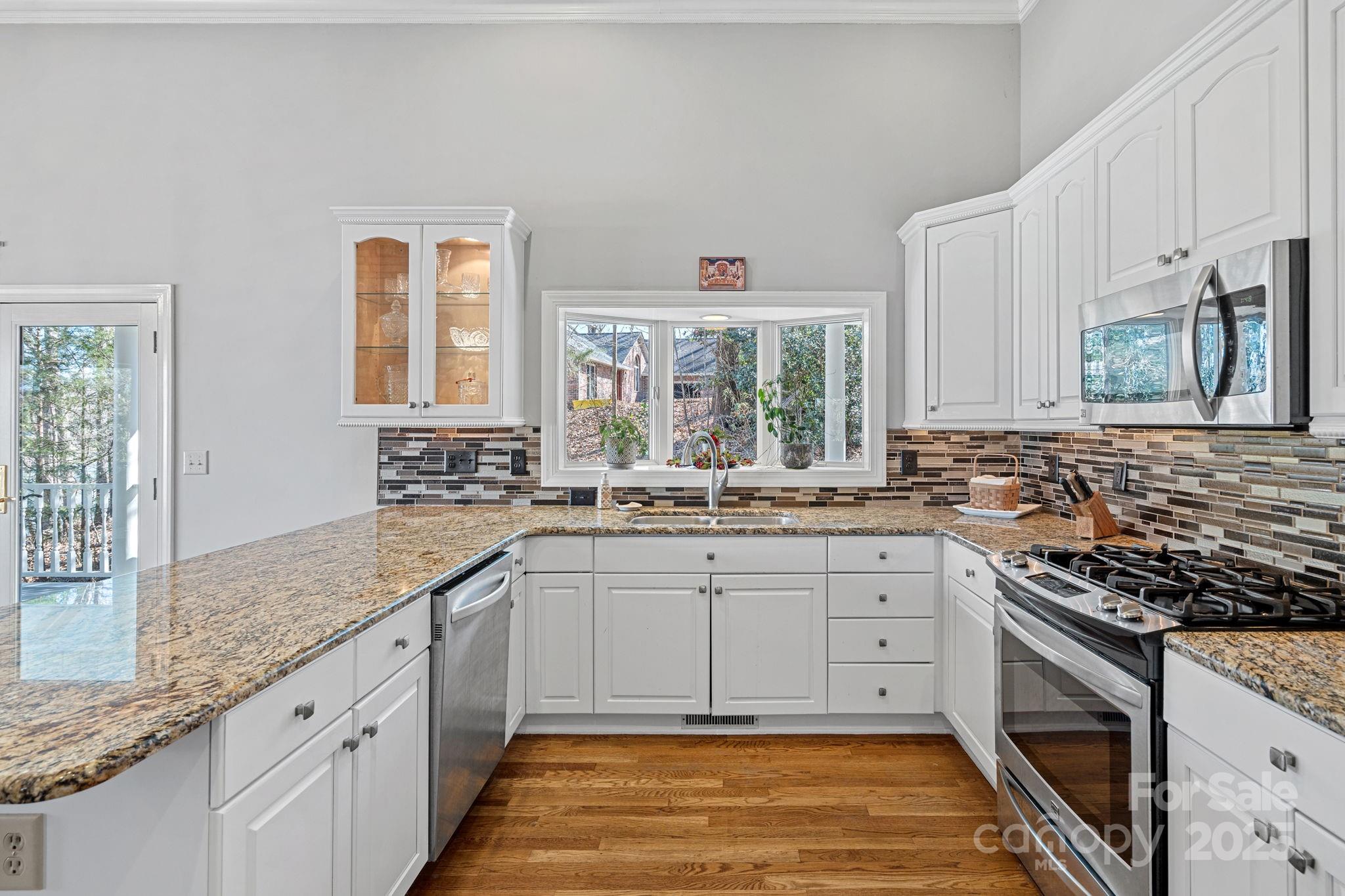 213 Patternote Road Mooresville, NC 28117 - Photo 16 of 48 a kitchen with granite countertop stainless steel appliances sink stove microwave and cabinets